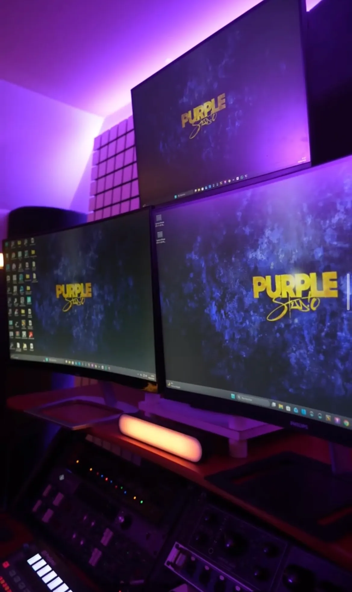 Le setup triple écran du Purple Studio avec le logo affiché